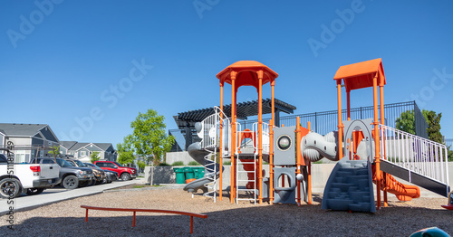 Wide shot of children's playground with parking lot