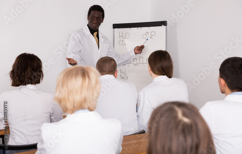 African American business man speaking to group of physicians in conference room.