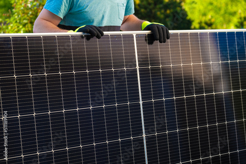 Solar energy.Green energy. Solar panel in the hands of a worker in a summer garden. Fitting and installation of solar panels.alternative energy from nature.solar power technology. 