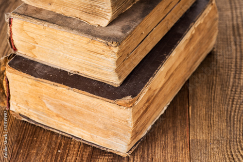 stack of three vintage shabby books on an old wooden table.macro. Selective focus.