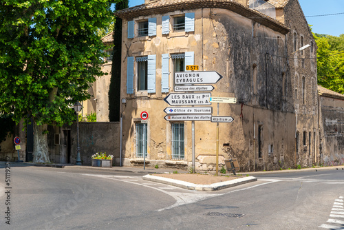 Sign posts pointing towards Avignon, the Alpilles and the tourism office at an intersection in the medieval center of Saint-Remy-de-Provence in Provence, France. photo