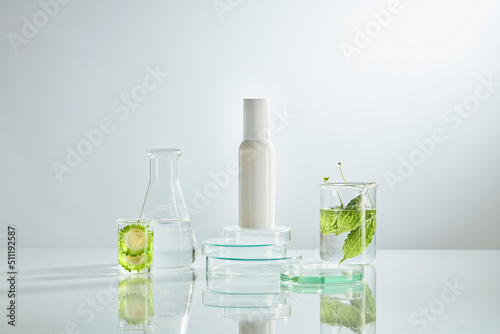 Front view of bitter melon with cosmetic jar decorated with laboratory equipment in green background 