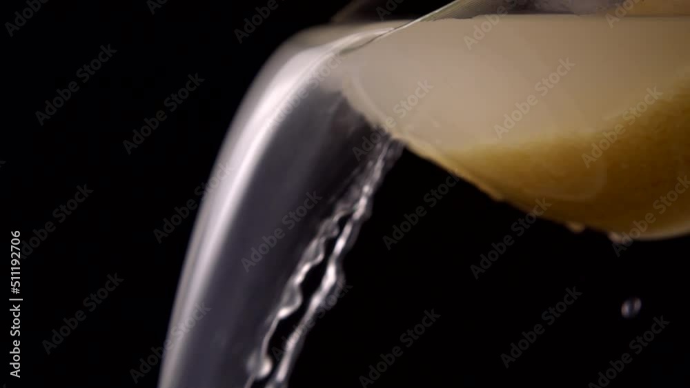 Washing rice, water pours from a bowl on a black background. Slow motion.