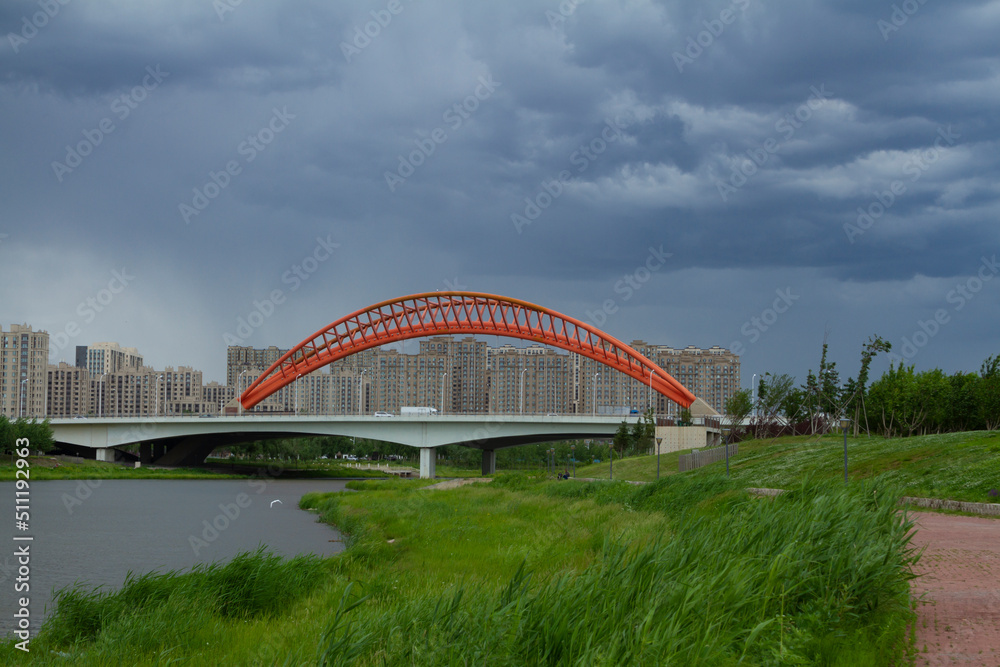 Naklejka premium Changchun, Jilin - June 3 2021: Modern bridge by a city park in summer.