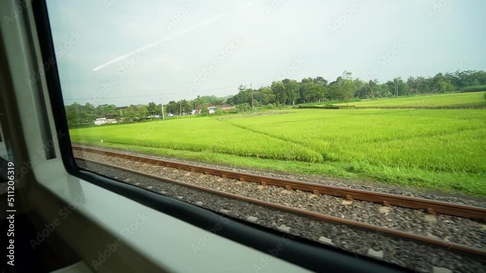 Ride the train sitting by the window looking at the view of the tracks and rice fields outside the window the train is speeding towards its destination Ride the train sitting by the window looking at the view of the tracks and rice fields outside the window the train is speeding towards its destination