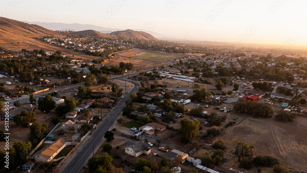 Fototapeta premium Sunset aerial view of the city and surrounding mountains of Jurupa Valley, California, USA.