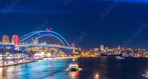 Colourful Light show at night on Sydney Harbour NSW Australia. The bridge illuminated with lasers and neon coloured lights  © Elias Bitar