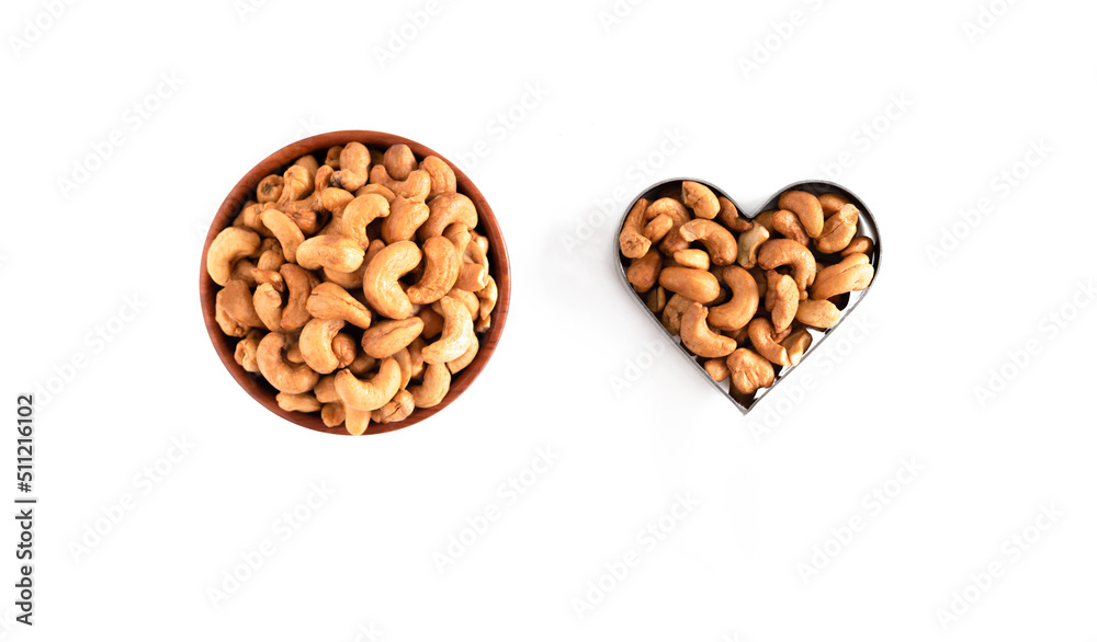 Top view of raw cashews in wooden bowl isolated on white background. Top view of raw cashews in wooden bowl isolated on white background.