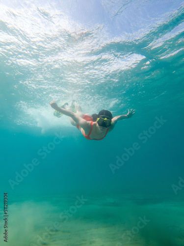 woman diving underwater in scuba mask and flippers