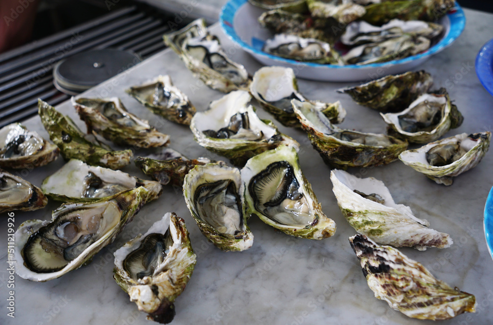 Fresh half oysters being prepped for a barbecue Fresh half oysters being prepped for a barbecue