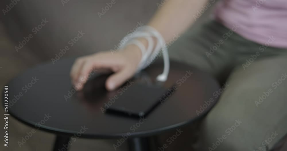 Addiction from digital media. A view of a woman hand connected with a telephone in the room. Addiction from digital media. A view of a woman hand connected with a telephone in the room.