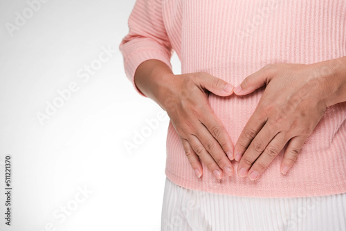 Close up of woman's hands made heart on belly isolated on white background. Young woman holding hands near belly. Early pregnant concept.