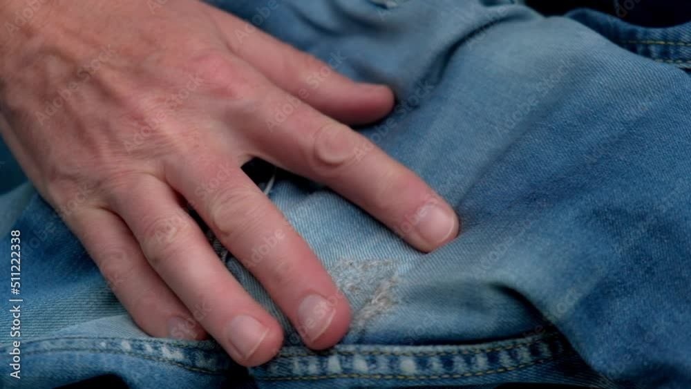 tailor checks quality of darning holes rubbed between legs on women's jeans.close-up of hands examining quality of sewing repair holes on jeans.concept of clothing repair or waste recycling.slowmotion tailor checks quality of darning holes rubbed between legs on women's jeans.close-up of hands examining quality of sewing repair holes on jeans.concept of clothing repair or waste recycling.slowmotion