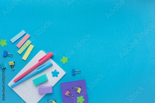Back to school flat lay. Various office supplies on blue background  space for text