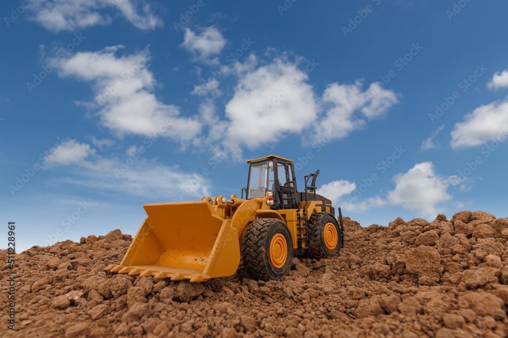 Wheel loader are digging the soil in the construction site on sky and cloud background . Wheel loader are digging the soil in the construction site on sky and cloud background .