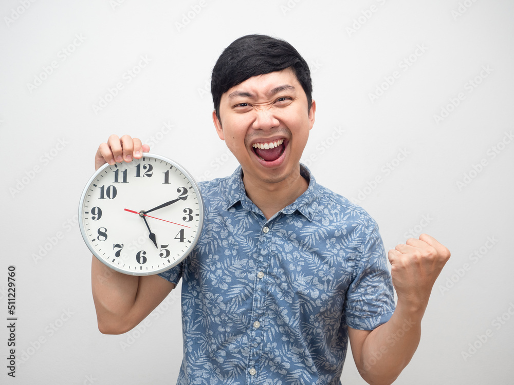 Positive man happy smile about finish working fist up showing analog clock pm