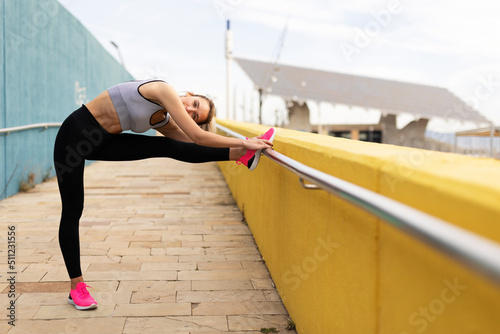 Young woman doing stretching exercise after running outside. Healthy lifestyle