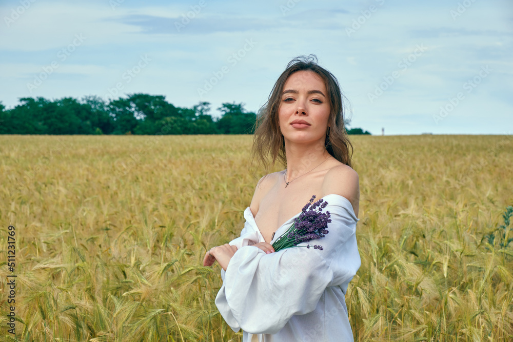 Portrait of a young girl in a field with wheat
