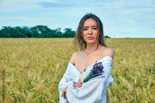 Portrait of a young girl in a field with wheat