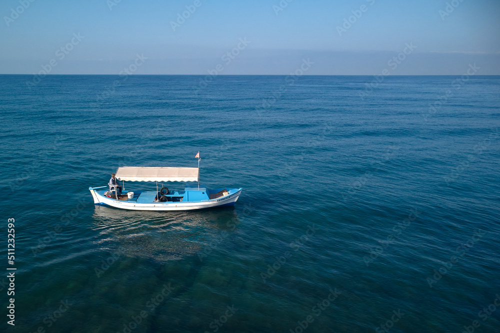 lonely fishing boat in the middle of the sea