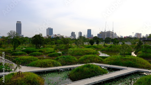 BANGKOK, THAILAND June 1, 2022 : Skywalk crisscrossing a lovely view of wetland and high rise buildings at  Benjakitti Park. photo