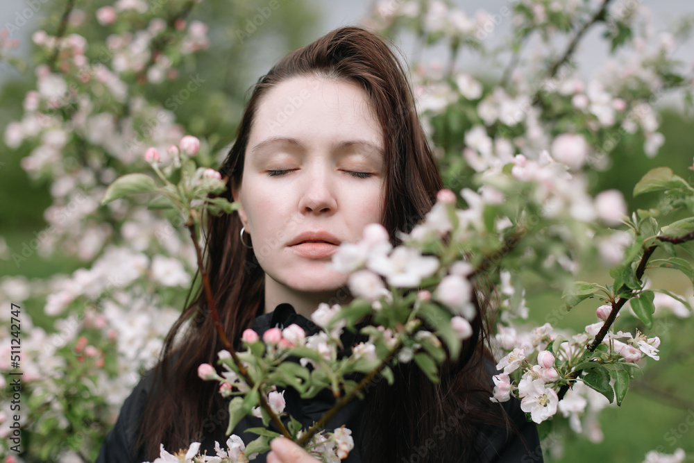 portrait of a beautiful young woman in the spring garden among apple blossom. portrait of a beautiful young woman in the spring garden among apple blossom.