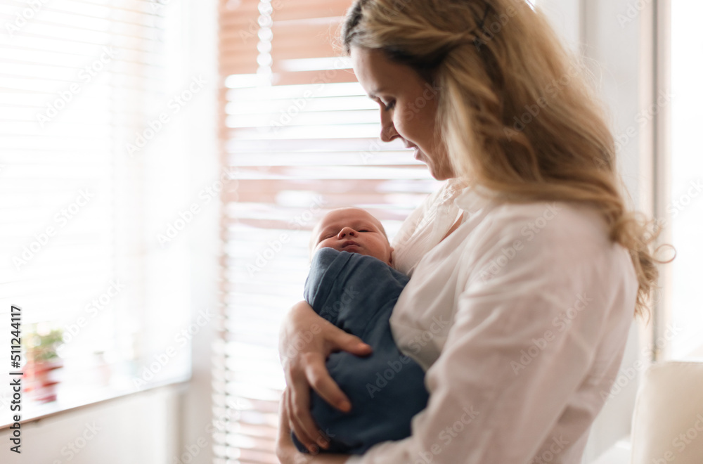 Young mother holding her newborn son at home. Young mother holding her newborn son at home.