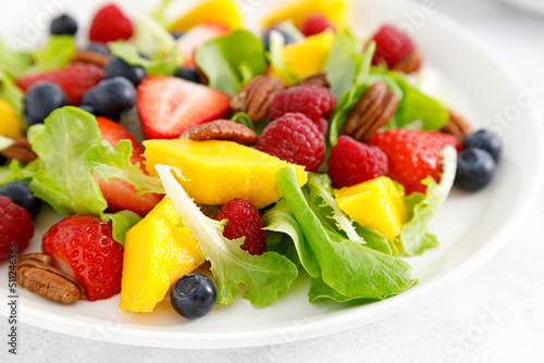 Fruit and berry salad with strawberry  blueberry  raspberry  mango and pecan nuts. Healthy food  diet