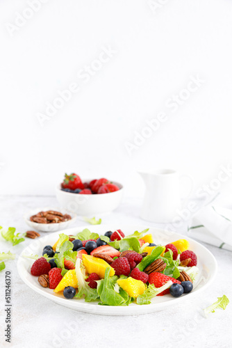 Fruit and berry salad with strawberry  blueberry  raspberry  mango and pecan nuts. Healthy food  diet