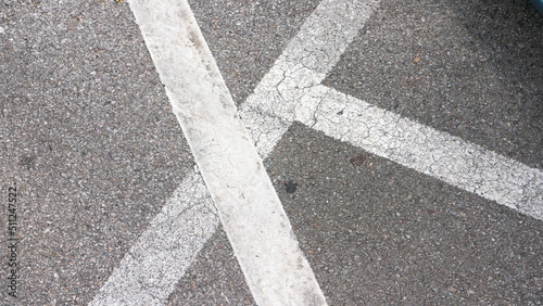 Líneas blancas de parking sobre asfalto gris