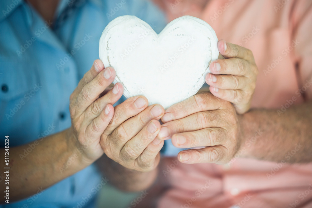 Close up of heart shape wooden decoration object. Concept of healhty senior lifestyle. Heart attack concept. Love and relationship with old mature man and woman hands. Together forever life. Dating Close up of heart shape wooden decoration object. Concept of healhty senior lifestyle. Heart attack concept. Love and relationship with old mature man and woman hands. Together forever life. Dating