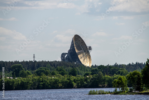 Fototapeta Naklejka Na Ścianę i Meble -  a huge space antenna radio telescope against the background of a forest and a river