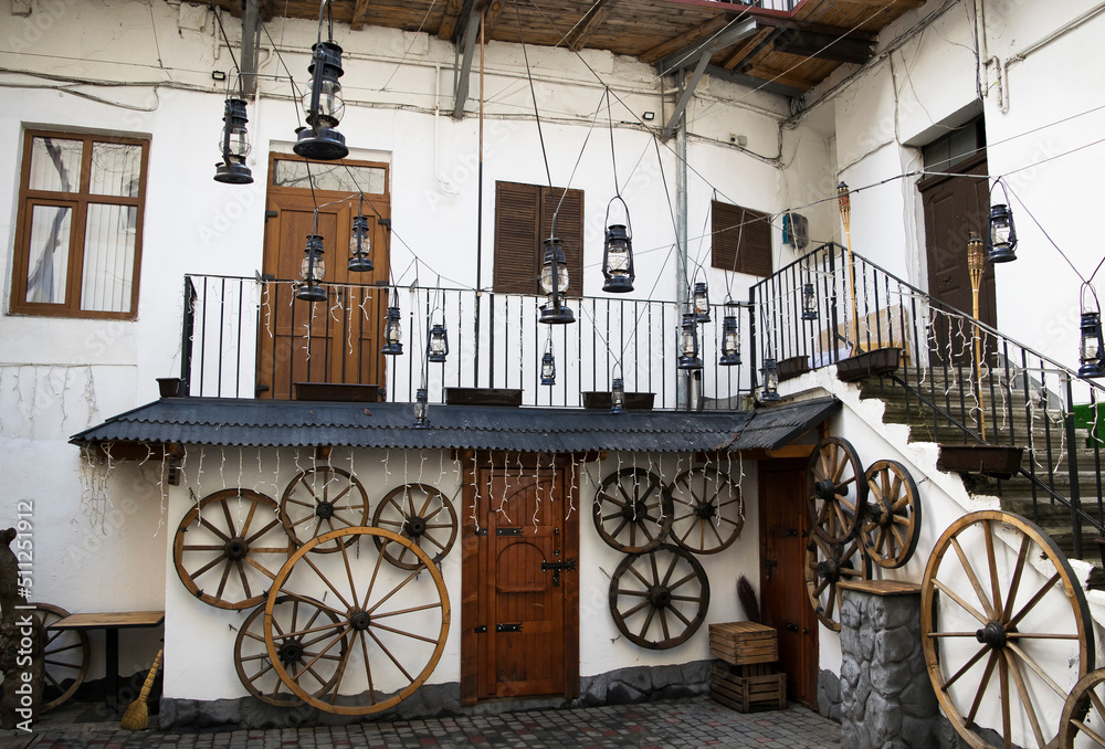 Courtyard with old wooden wheels, gas lamps and bellows in Chernivtsi city, Ukraine