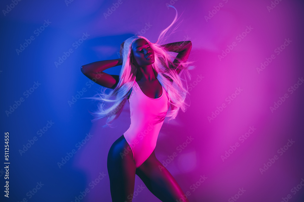 Beautiful photo of charming lady posing in nightclub feel air flying hair isolated on pink fluorescent background Beautiful photo of charming lady posing in nightclub feel air flying hair isolated on pink fluorescent background