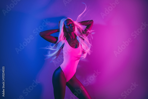 Beautiful photo of charming lady posing in nightclub feel air flying hair isolated on pink fluorescent background