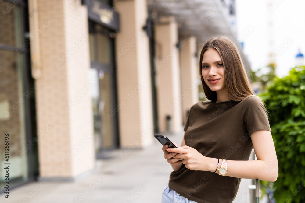Business woman uses by mobile phone outdoors walking along the street Business woman uses by mobile phone outdoors walking along the street