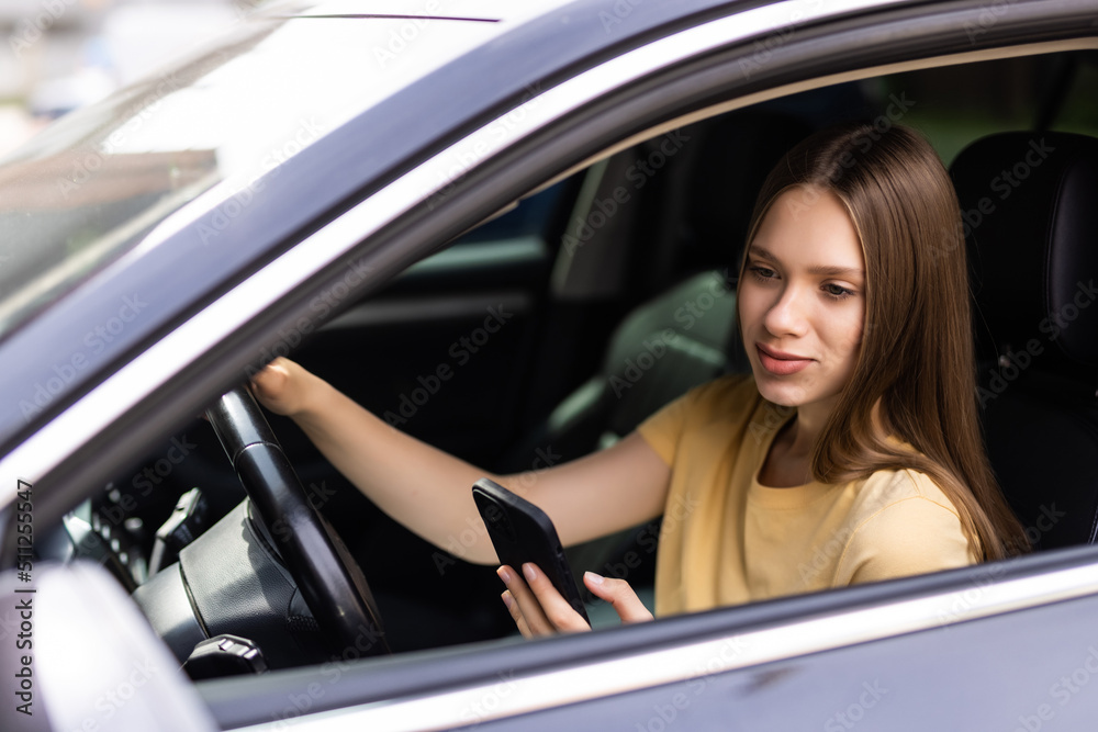 Attractive woman uses smart phone while driving. Attractive woman uses smart phone while driving.