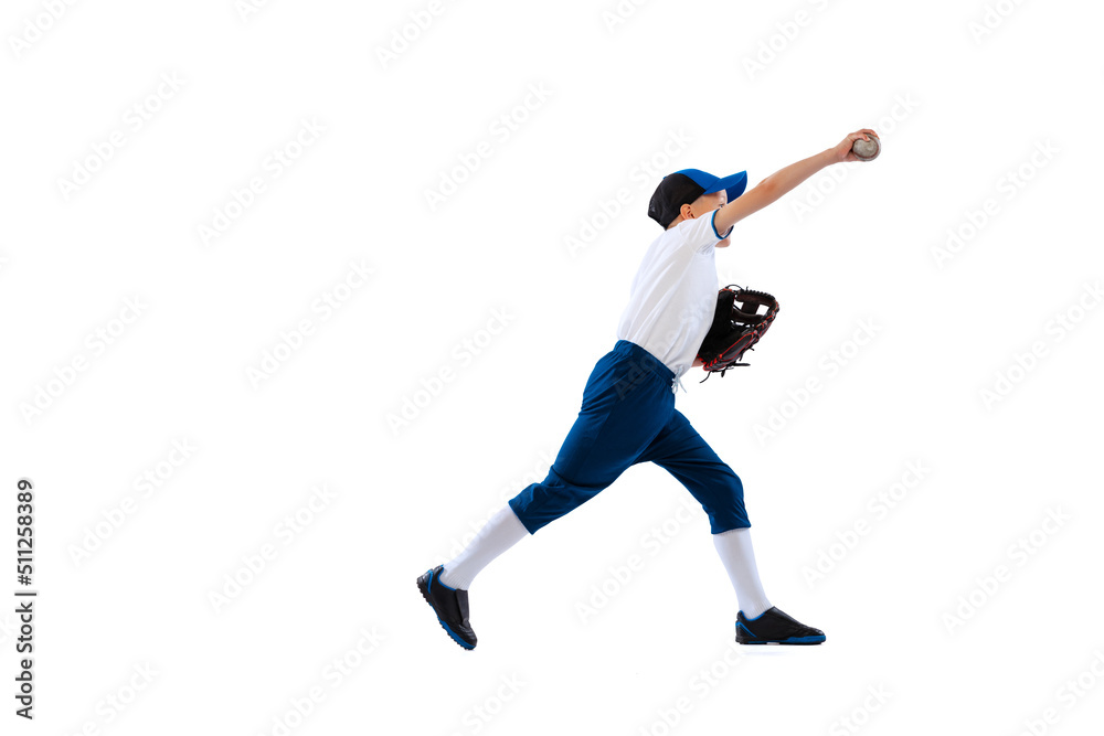 Studio shot of sportive kid, beginner baseball player in sports uniform playing baseball isolated on white background. Concept of sport, achievements, competition