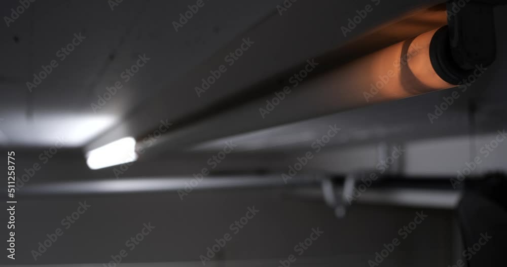 Broken neon-light tube flickering on a ceiling wall. Close up shot, real time, no people Broken neon-light tube flickering on a ceiling wall. Close up shot, real time, no people
