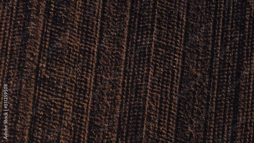 Flying away rotating vertical shot with a drone of a plowed field Flying away rotating vertical shot with a drone of a plowed field