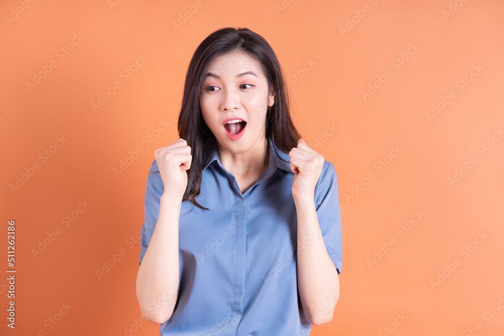 Young Asian business woman posing on orange background Young Asian business woman posing on orange background