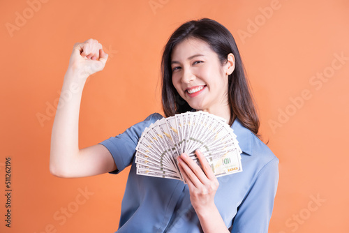 Young Asian business woman posing on orange background photo