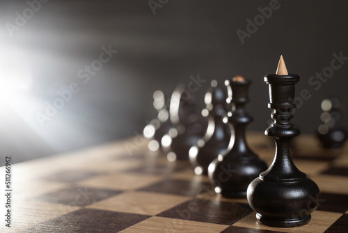 Chess board game is concept of business ideas and competition and strategy ideas of concealment. Chess pieces on dark background with rays. Selective focus. Copy space
