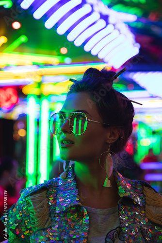Photography Stylish woman wearing jacket with shining sequins on the city street with neon l