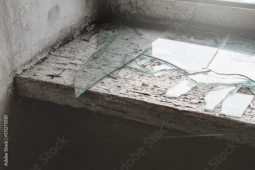 Windowsill with spider web and broken glass in abandoned building.