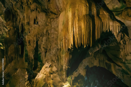 Natural dark underground cave with strangely shaped stalactites.