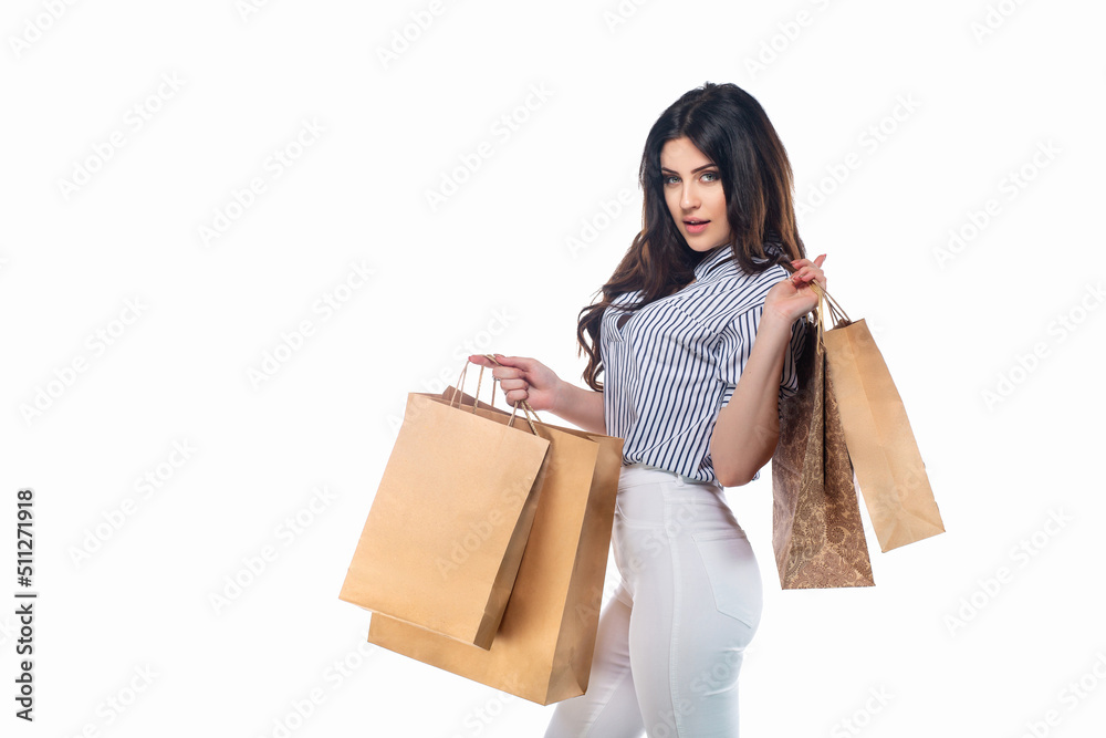 Beautiful brunnet сaucasian young girl in white pants and striped shirt holding shopping bags isolated on white background Beautiful brunnet сaucasian young girl in white pants and striped shirt holding shopping bags isolated on white background