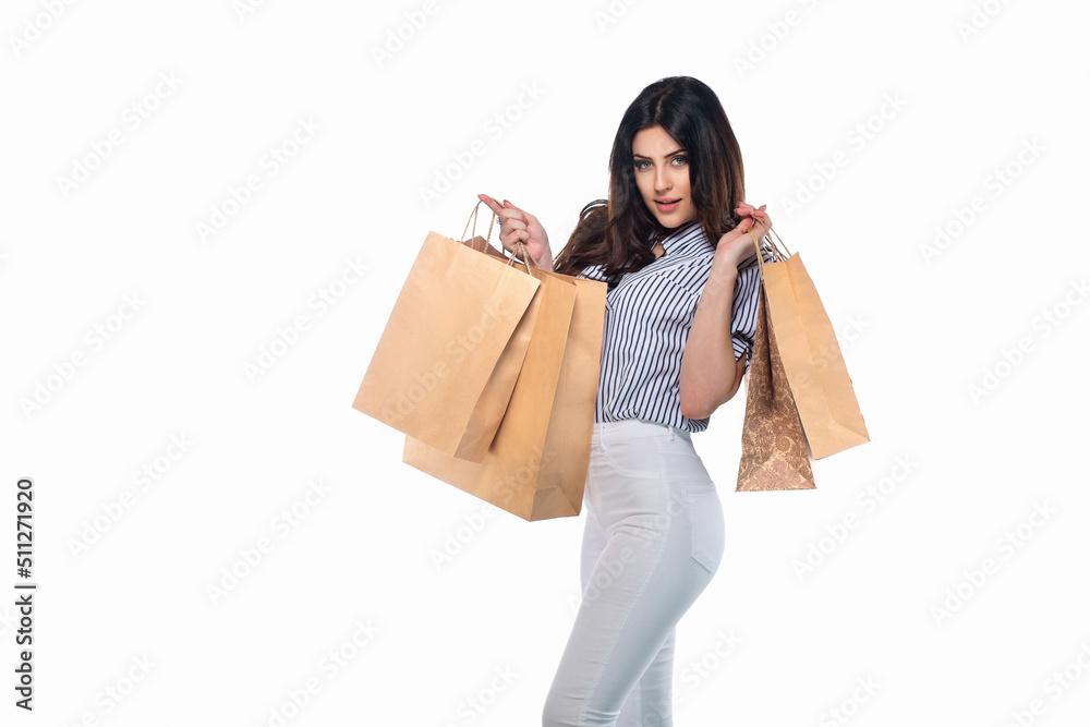 Beautiful brunnet сaucasian young girl in white pants and striped shirt holding shopping bags isolated on white background Beautiful brunnet сaucasian young girl in white pants and striped shirt holding shopping bags isolated on white background