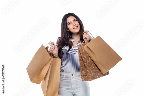 Beautiful brunnet сaucasian young girl in white pants and striped shirt holding shopping bags isolated on white background photo