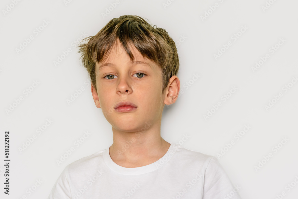 The child confidently looks directly into the camera . Portrait of a white Caucasian 9yearold